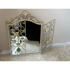 a mirror sitting on top of a tiled floor next to a white wall and tile floor