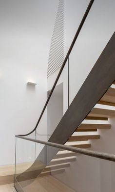 a staircase with glass railing and wooden handrail