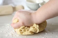 a person is kneading dough into a ball