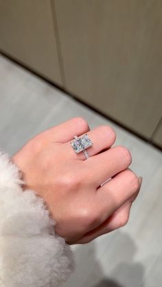 a woman's hand with a diamond ring on it