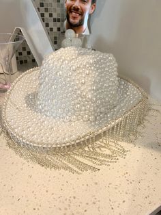 The perfect hat to hit the town running on your bachelorette. This hand made cowboy hat is covered in white pearls and finished with a fringe. Don't miss out on this beautiful custom hat! Diy Bedazzled Cowboy Hat, Pearl Cowboy Hat, White Fedora Mini Hat For Party, White Beaded Hats For Festival, White Beaded Hat With Short Brim, White Beaded Curved Brim Hat, White Beaded Short Brim Hat, Bridal Cowboy Hat, Bedazzled Cowboy Hat