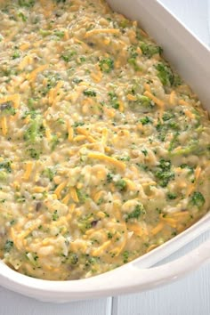 a casserole dish with cheese and broccoli in it on a white table