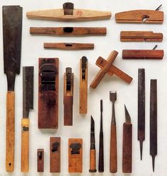 many different types of woodworking tools are laid out on a white surface with wooden handles