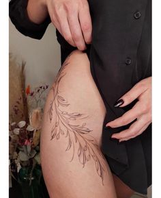 a woman is showing off her tattoo on her thigh