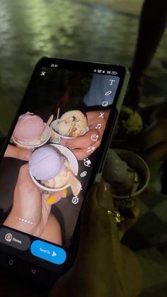 a person holding up a cell phone with an image of two people eating ice cream