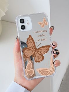 a woman holding up her phone case with butterflies on it and the words everything will be all right