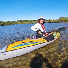 a man in a hat and sunglasses is sitting in a kayak on the water