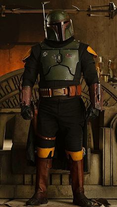 a man dressed as boba fett standing in front of a fire place with his hands on his hips