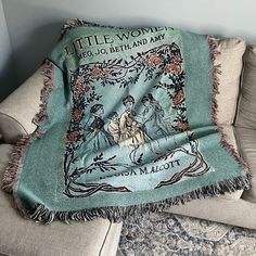 a throw blanket on a couch with an image of a woman riding a horse in the background