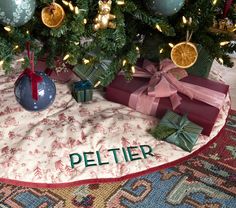 a christmas tree with presents under it and the words peltier written on them