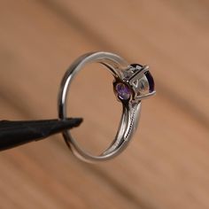 It is a natural amethyst ring. The main stone is 7mm*7mm round cut, weight about 1.25 carats. The basic metal is sterling silver and plated with rhodium. To change the metal to a solid gold (white/rose) or platinum is also available, please ask for a quotation if you want. You can also go to my shop Home for more elegant rings: https://www.etsy.com/shop/godjewelry?ref=hdr_shop_menu More amethyst rings: https://www.etsy.com/shop/godjewelry?ref=seller-platform-mcnav&section_id=20709248 Customi Birthstone Ring With Halo Setting For Promise, Halo Setting Birthstone Ring For Promise, Promise Ring With Round Birthstone In Halo Setting, Purple Crystal Ring With Halo Setting, Classic Amethyst Round Cut Birthstone Ring, Amethyst Round Cut Diamond Ring Birthstone, Amethyst Round Cut Diamond Birthstone Ring, Amethyst Diamond Ring With Round Cut, Amethyst Diamond Birthstone Ring With Round Cut