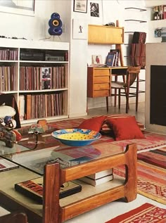 a living room filled with furniture and a fire place next to a book shelf full of books