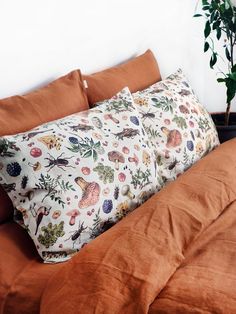 an orange bed with two pillows and a potted plant on the nightstand next to it