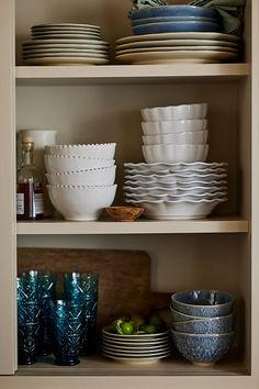 the shelves are filled with dishes and bowls