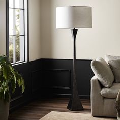 a living room scene with focus on the floor lamp and couch in the foreground