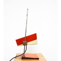 a lamp that is sitting on top of a wooden table next to a red book