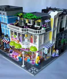 a lego house is shown with people in the front yard and on the second floor