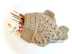 a crocheted purse with scissors and other crafting supplies next to it on a white surface