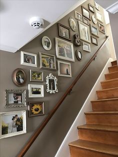 a staircase with pictures on the wall and framed photos on the wall next to it