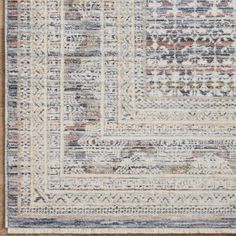 an area rug with multicolored stripes and fringes on the bottom, along with a wooden floor