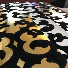 the black and gold table cloth has an intricate design on it's side,