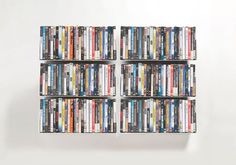 a wall mounted shelf filled with lots of dvd's