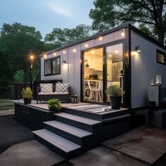 a tiny house with stairs leading up to the front door and outside living room area