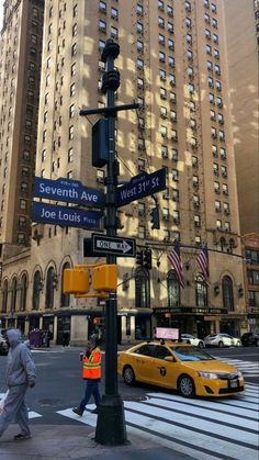 people crossing the street at an intersection in new york city, with tall buildings behind them