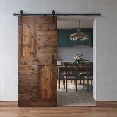 an open door leading to a kitchen and dining room with wooden floors, white walls and green cabinetry