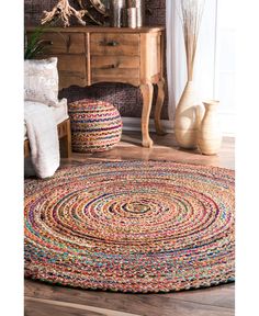 a round rug with multicolored braids on the floor in a living room