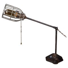 a metal lamp with a chain hanging from it's arm and a light bulb on top