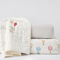 three baby blankets are stacked on top of each other, with hot air balloons printed on them