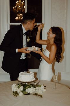 a bride and groom feeding each other cake