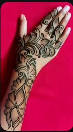 a woman's hand with henna tattoos on her left arm and the wrist