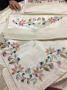 two white cloths with embroidered flowers on them