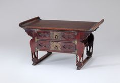 an old wooden table with two drawers on one side and a drawer on the other