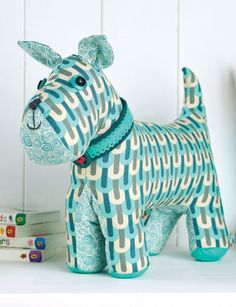 a blue and white dog figurine sitting on top of a table next to books