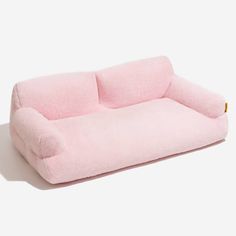 a pink dog bed that is shaped like a couch