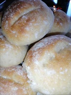 a pile of doughnuts sitting on top of a metal pan covered in powdered sugar