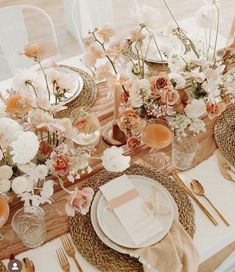 the table is set with flowers and place settings