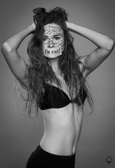 a woman with her face painted in the shape of a mask and words on her face