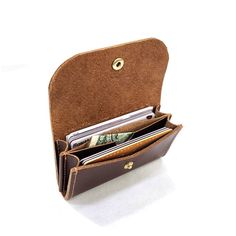 an open wallet with money sticking out of it's front pocket on a white surface