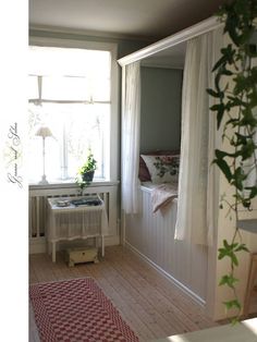 a room with a bed, window and rug on the floor in front of it