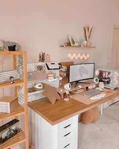 a desk with a computer on top of it next to a shelf filled with books