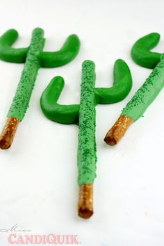 three green candles with sticks sticking out of them