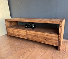 a wooden entertainment center with shoes on top