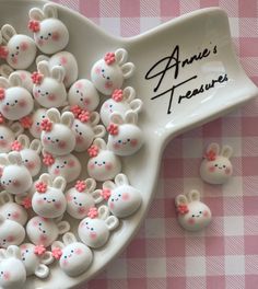 there are many small white and pink candies in the bowl on the table next to each other