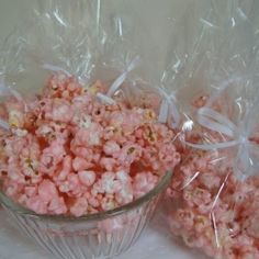 two bags of popcorn sitting next to each other on a white tablecloth covered table