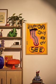 a shelf filled with books and vases next to a wall mounted poster on the wall