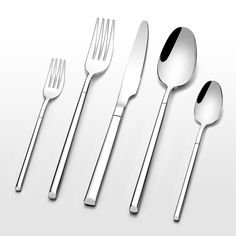 three forks, two spoons and one knife on a white surface with shadows in the background